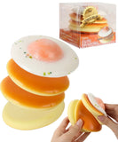 Grabie Ultimate Stress Relief Squishy shaped like a stack of pancakes with a fried egg on top being squeezed by hands