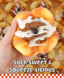 Hand holding a realistic squishy dessert toy with icing and a berry, Grabie Ultimate Stress Relief Squishy.