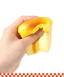 Hand squeezing bright yellow and orange Grabie Ultimate Stress Relief Squishy toy against white background