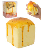 Grabie Ultimate Stress Relief Squishy shaped like a melting butter cube with yellow and orange details in hand and packaging.
