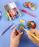Artist using Extra Fine Tip Acrylic Paint Marker Set With Iridescent Glitter Acrylic Paint Marker Set to paint colorful designs on stones